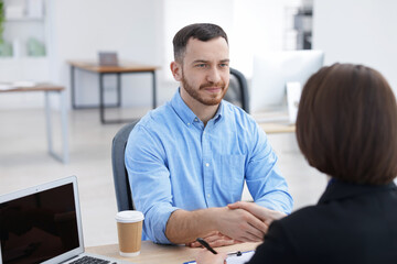 Obraz premium Recruiter and candidate shaking hands at desk in office