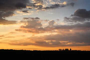 Incredible sunset with dramatic clouds and warm golden light in evening sky