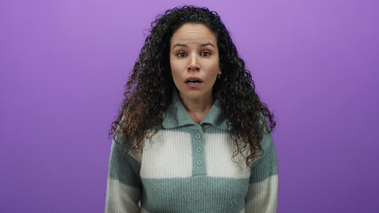 Woman expressing emotion in a video frame over a purple background, wearing a sweater, isolated,...