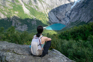 Female Hiker Admiring Glacial Lake from Mountain Viewpoint at Briksdalsbreen, Norway