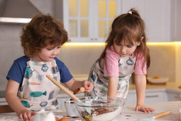 Fototapeta premium Cooking recipe. Cute children making dough for cookies at table in kitchen