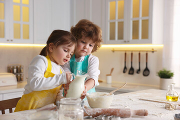 Cooking recipe. Cute children making dough for cookies at table in kitchen
