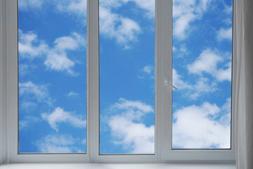View from the window of a blue sky with white clouds.