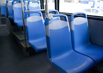 Blue plastic seats in modern public transport bus interior with clean lines and spacious design for...