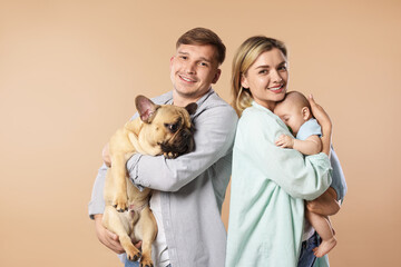 Happy family with little baby and cute dog on beige background