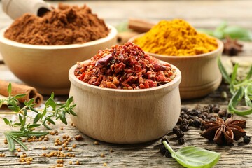 Different aromatic spices on wooden table, closeup