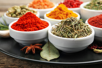 Different aromatic spices on wooden table, closeup