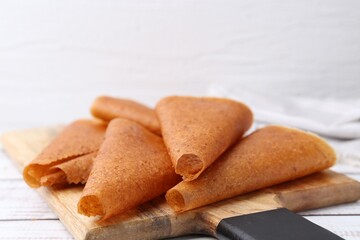 Delicious fruit leather rolls on white wooden table, closeup