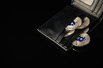 Cryptocurrency. Bitcoins in wallet on black mirror surface, above view. Space for text