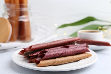 Tasty fruit leather rolls on white table