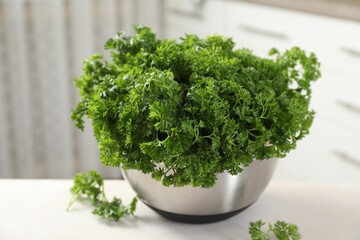 Fototapeta premium Fresh parsley in bowl on table indoors