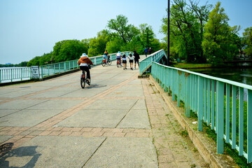 pedestrians and cyclists crossing a bridge on center island on the toronto islands a public park in early summer