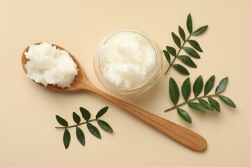 Shea butter and leaves on beige background, flat lay