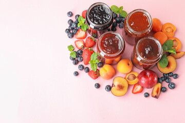 Different jams in jars and ingredients on light pink background, flat lay. Space for text
