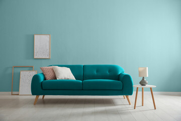 Stylish living room with comfortable sofa and light blue wall. Interior design