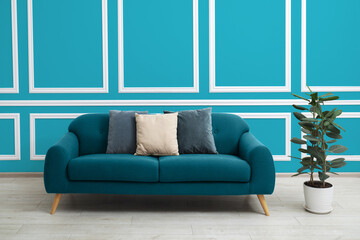 Stylish living room with comfortable sofa and blue wall. Interior design