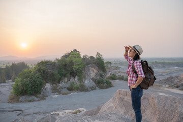 Hiker with backpack standing on top of a mountain and enjoying stunning valley view. adventure travel, camping and hiking in nature. concept adventure summer vacations outdoor mountaineering sport.