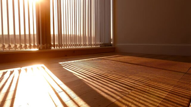 Sunlight casts shadows on wooden floor through blinds