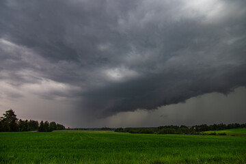 WEATHER - Dramatic black rain clouds over fields and country road.