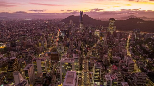LAS CONDES, CHILE &ndash; AUGUST, 10, 2023. Dynamic hyperlapse: Drone advances forward over Santiago. Captures sunset, Gran Torre Santiago, and Andes mountains. Stunning aerial view of city at dusk