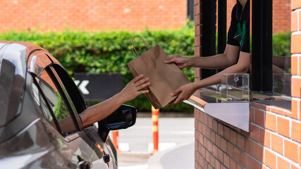 Picking up coffee or water through a drive-thru during busy hours, a concept of efficient takeaway...