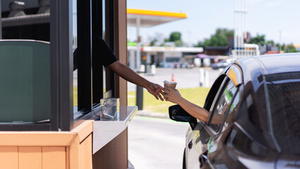 Picking up coffee or water through a drive-thru during busy hours, a concept of efficient takeaway...