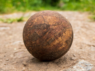 Old Textured Ball Resting on Uneven Ground
