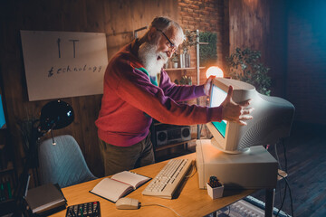 Experienced professional working with vintage computer technology in a cozy home office setting...