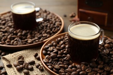 Aromatic coffee in cups and beans on table, closeup