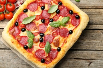 Tasty homemade pizza and ingredients on wooden table, flat lay
