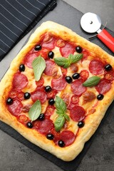 Tasty homemade pizza and cutter on grey table, top view