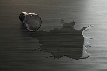 Overturned glass and spilled water on wooden table