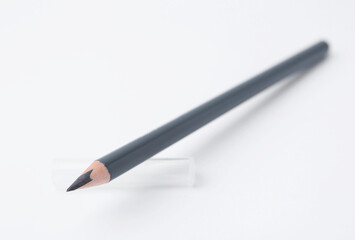 Grey eyebrow pencil on white background, closeup