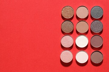 Beautiful eyeshadow refill pans on red background, flat lay. Space for text