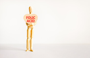 Folic acid symbol. Concept words Folic acid on beautiful wooden heart. Doctor's model. Beautiful white background. Copy space. Medical healthy lifestyle folic acid concept.