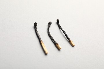 Burnt matches on light grey background, closeup