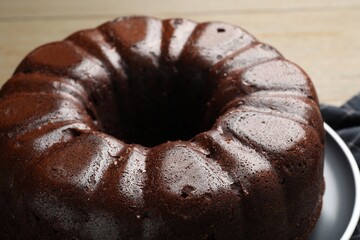 Tasty chocolate bundt cake on wooden table, closeup