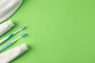 Different oral care products on green background, flat lay. Space for text
