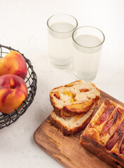 Peach cake loaf on wooden cutting board on white backgroud