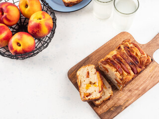 Peach cake loaf on wooden cutting board on white backgroud