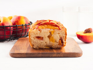Peach cake loaf on wooden cutting board on white backgroud