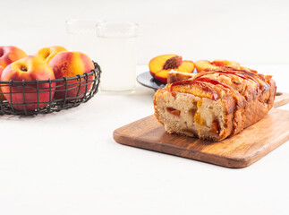 Peach cake loaf on wooden cutting board on white backgroud