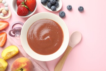 Baby food. Tasty puree in bowl, pacifier, teether and ingredients on pink background, flat lay