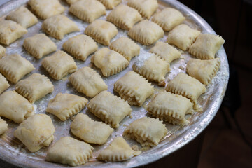 Traditional pastry preparation takes place in a kitchen with freshly made dough ready for baking