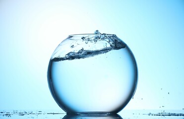 Glass aquarium with water on light blue background