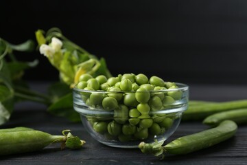 Fresh ripe green peas on black wooden table, closeup