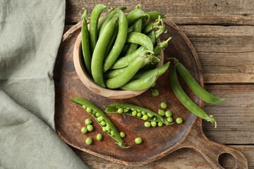 Fresh ripe green peas on wooden table, flat lay