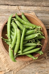Fresh ripe green peas on wooden table, top view