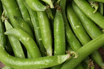 Fresh ripe green peas on wooden table, flat lay