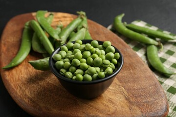 Fresh ripe green peas on black table, closeup
